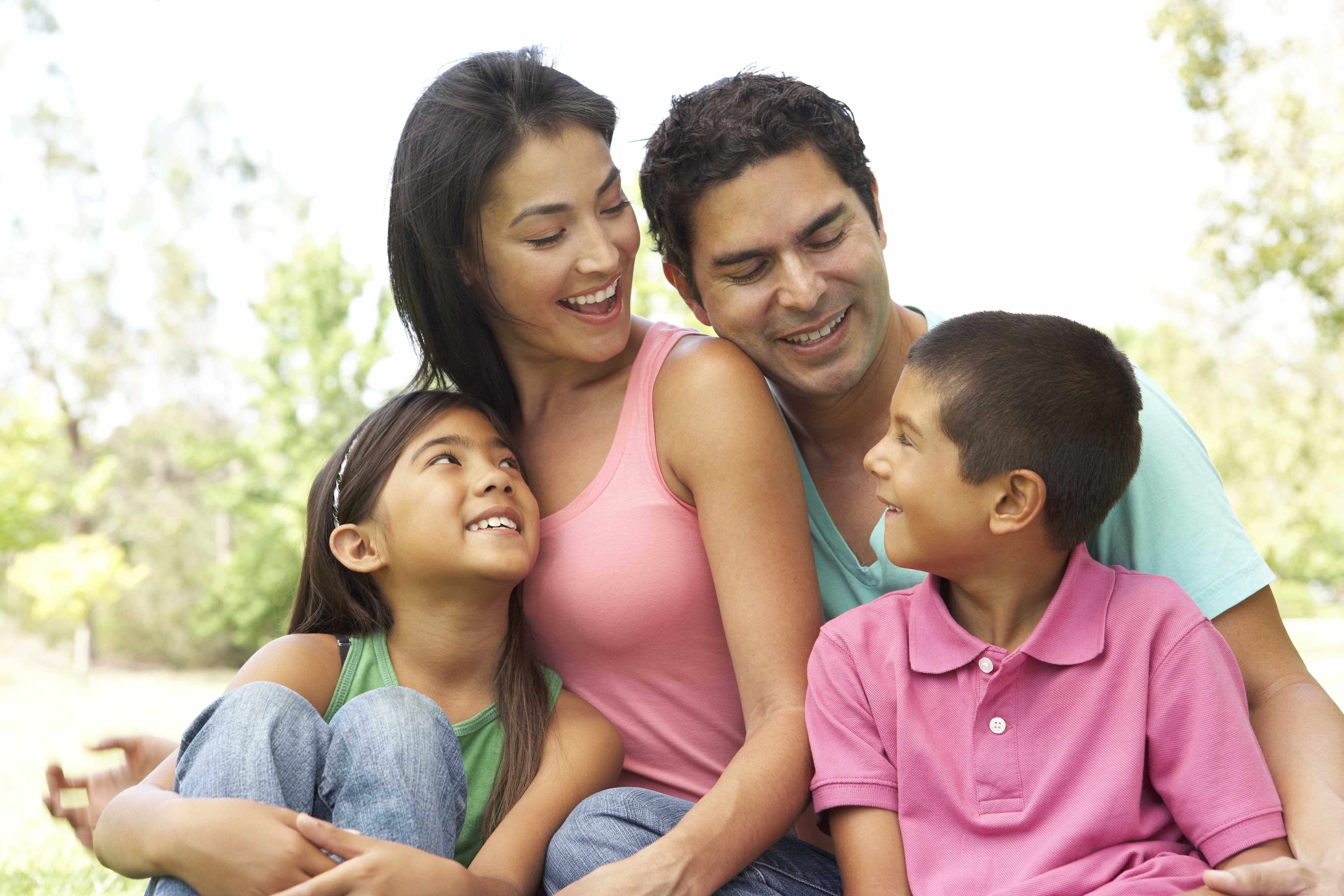 family of four smiling happily together