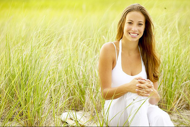 young brunette hair lady sitting in grass
